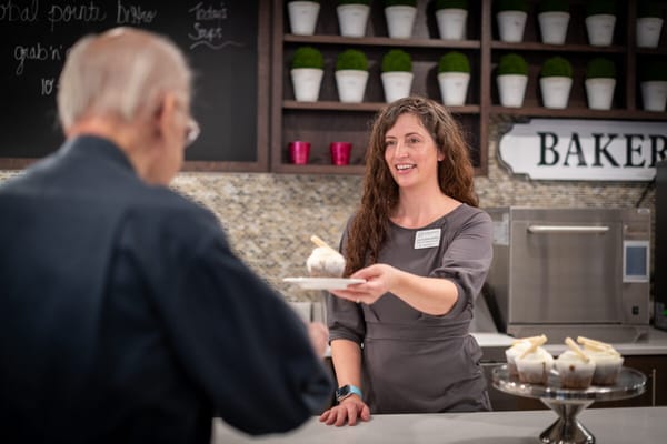 Staff member serving dessert to a resident