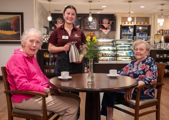 Two residents enjoying coffee with a staff member