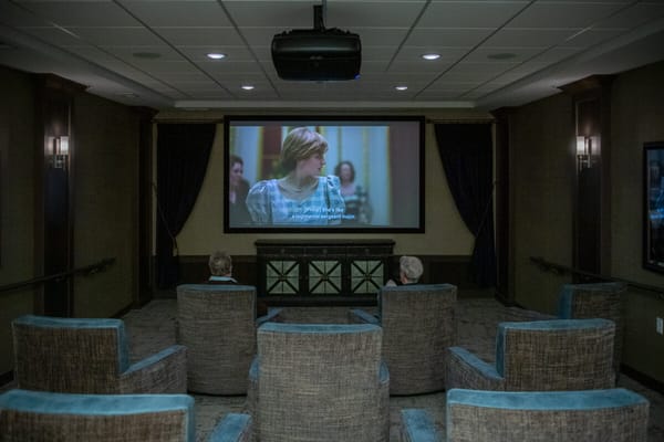 Residents watching a movie in a cozy theater room