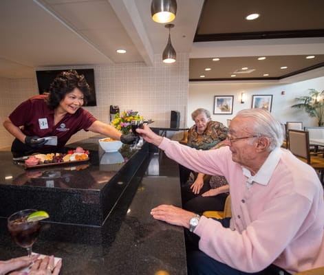 Staff serving food to residents in a dining area