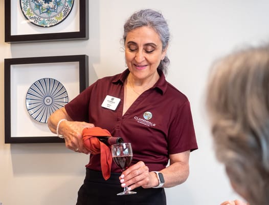 Staff member pouring wine for a resident