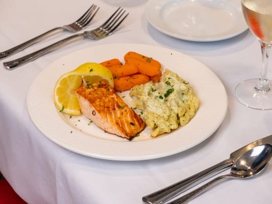 A meal featuring salmon, vegetables, and pasta on a white plate