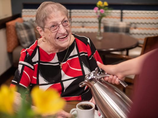 Resident enjoying coffee in a cozy dining area