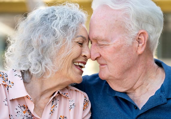 Elderly couple smiling closely together