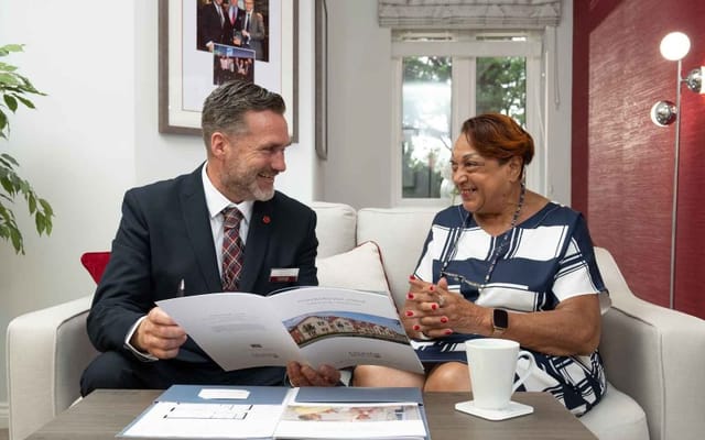 Staff and resident engaged in conversation in a comfortable interior