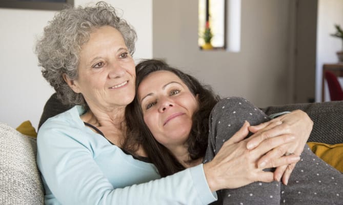A resident and caregiver sharing a moment in a cozy common area