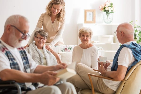 Residents enjoying time with staff in a cozy lounge