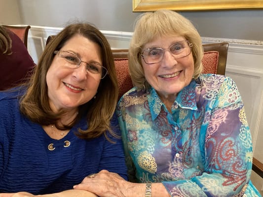 Two residents smiling together in a common area