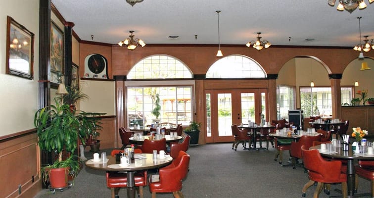 Dining room with red chairs and large windows