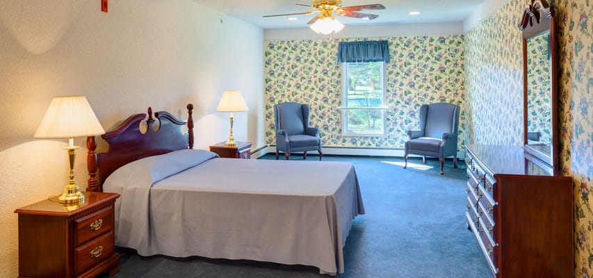 Brightly decorated resident room with floral wallpaper