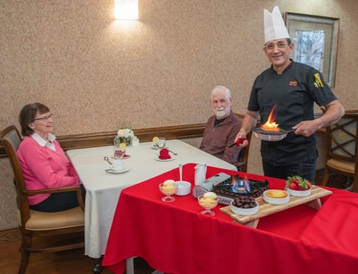 Chef preparing dessert for seniors in a dining setting