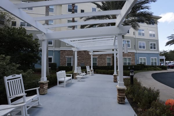 Outdoor seating area with rocking chairs and landscaping