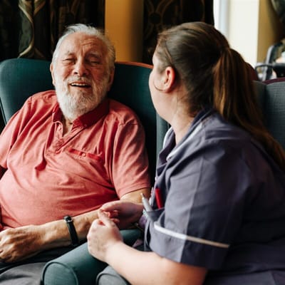 A resident and caregiver sharing a joyful moment