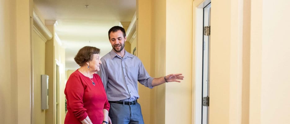 Staff member engaging with resident in a hallway