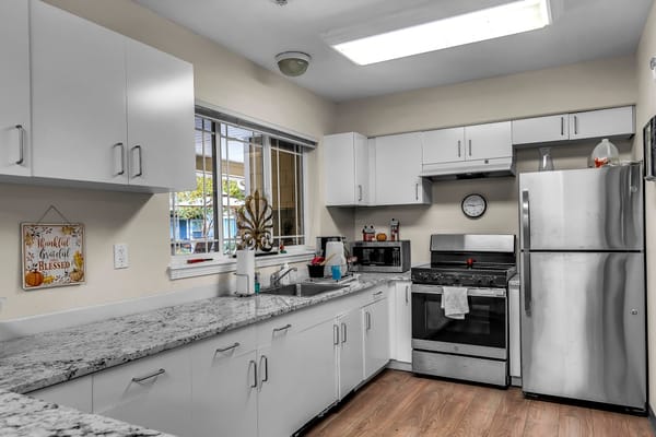 Bright kitchen with modern appliances and a granite countertop.