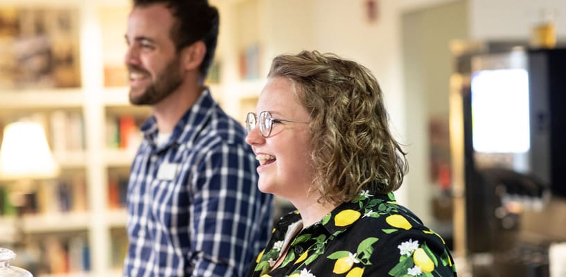 Two staff members smiling in a common area