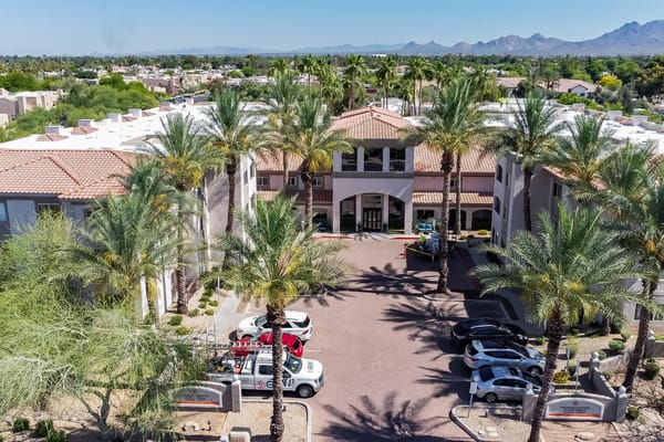 Aerial view of The Ranch Estates entrance with palm trees and vehicles
