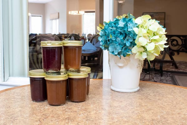 Cans of homemade preserves next to a decorative flower arrangement