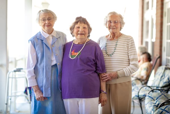 Three smiling residents enjoying the outdoor space