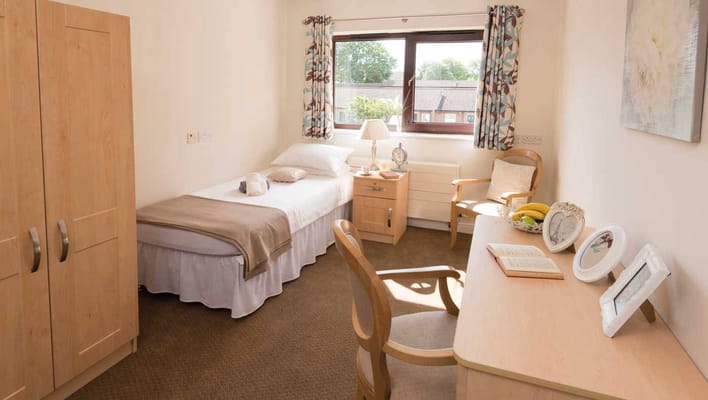 Brightly decorated private room with a bed and chair