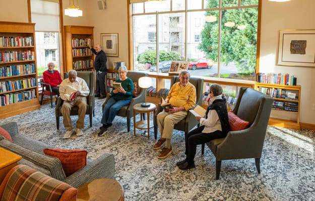 Residents reading books in a cozy library space