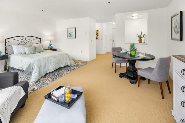 Stylish interior of a private resident room with a bed and dining area