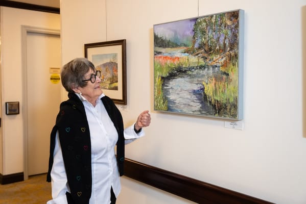Resident admiring artwork in the facility's common area