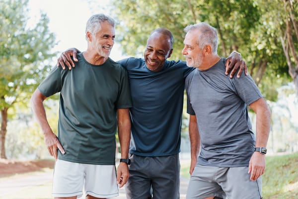 Three senior men laughing and enjoying time together outdoors