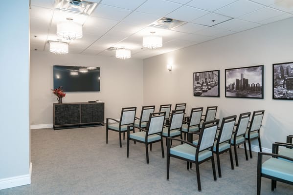 Interior view of a meeting room with chairs and a television