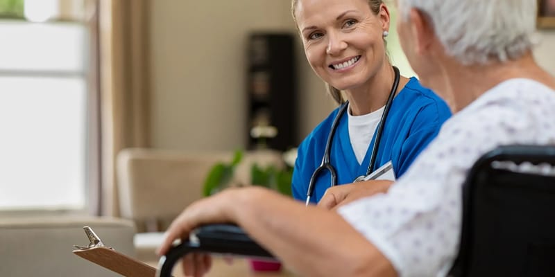 Healthcare professional talking to a resident in a bright room