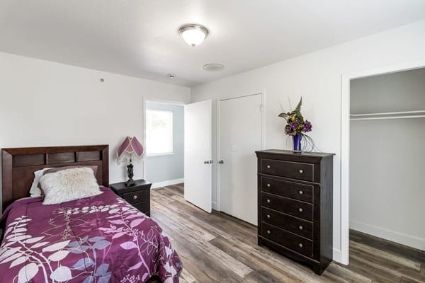 Bright private room with a bed and dresser