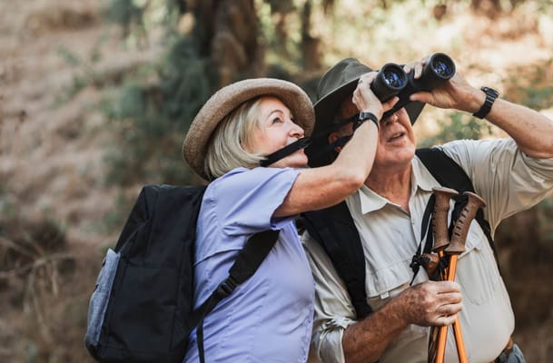 Couple hiking together with binoculars in nature