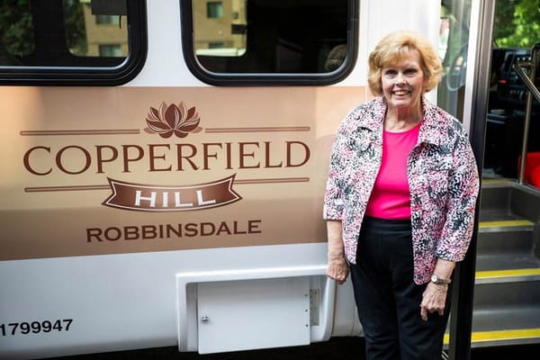 A resident beside the facility's transport van.