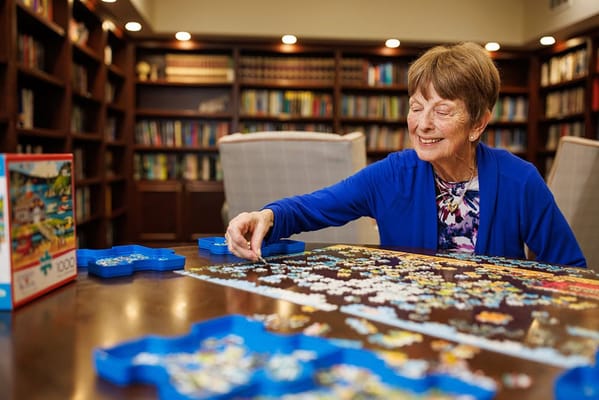 Resident enjoying a puzzle in a cozy library