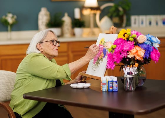 Resident painting in a colorful activity room