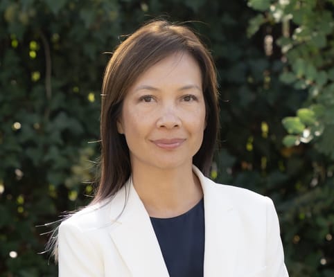 A woman in a white blazer standing outdoors