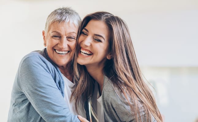 Two women laughing and embracing, showcasing joy and connection