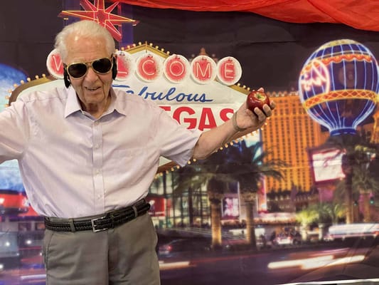 Resident celebrating with apple in a festive setting