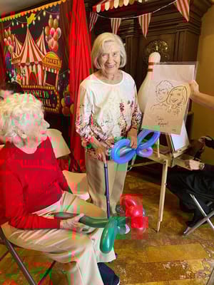 Residents enjoying a balloon art activity in a common area