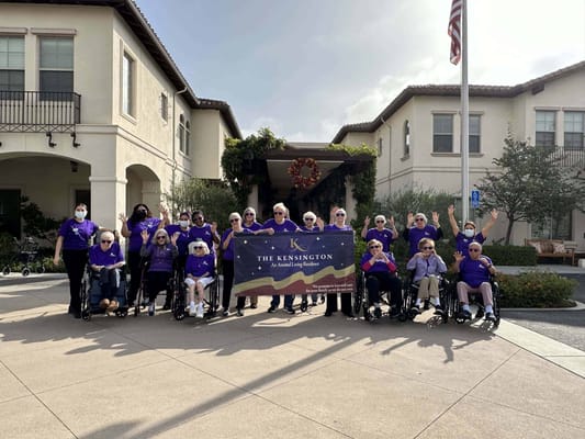 Residents and staff celebrating outside with a banner