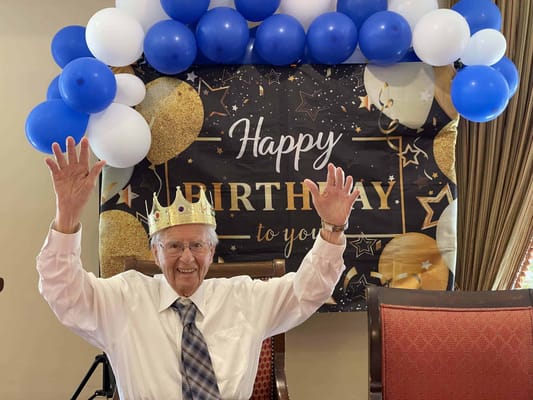 Resident celebrating a birthday with balloons and decorations