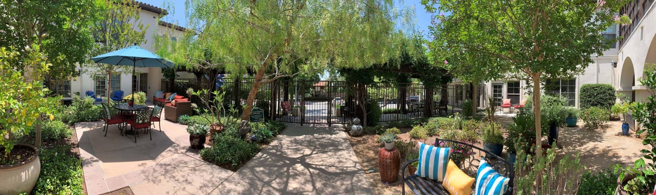 Lush outdoor courtyard with seating and shade