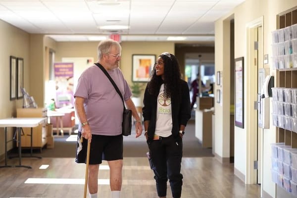 Resident and staff member interacting in a hallway