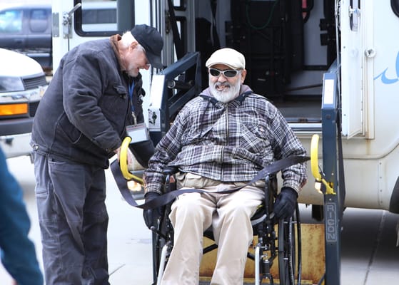 Staff assisting a resident in a wheelchair