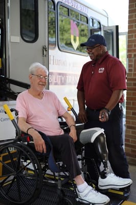 Resident in a wheelchair with transportation staff member