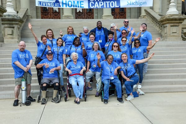 Group of residents and staff in blue shirts outside