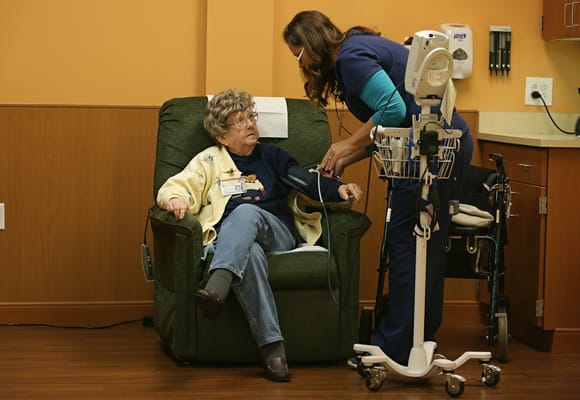 Nurse taking a resident's blood pressure in a cozy setting