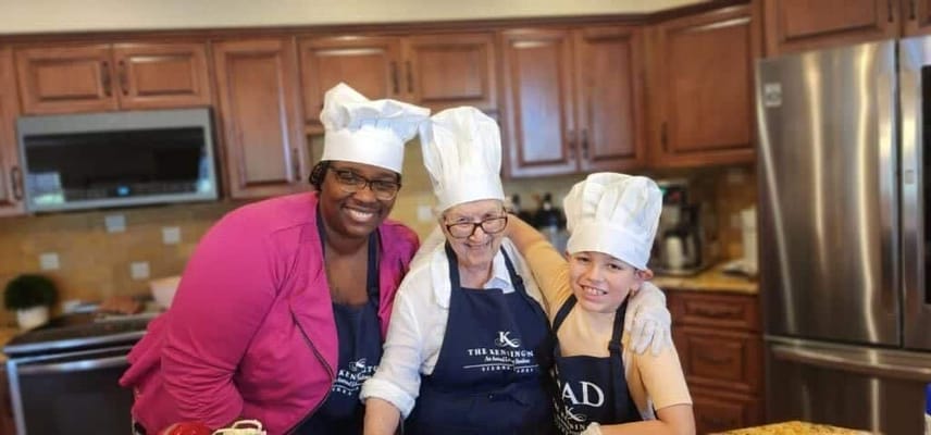 Residents and staff baking together in a kitchen