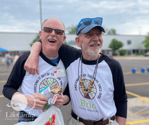 Two residents smiling and enjoying an outdoor event