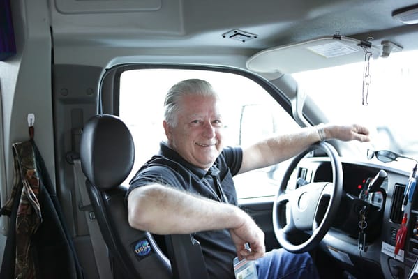 Man smiling in a vehicle driver's seat